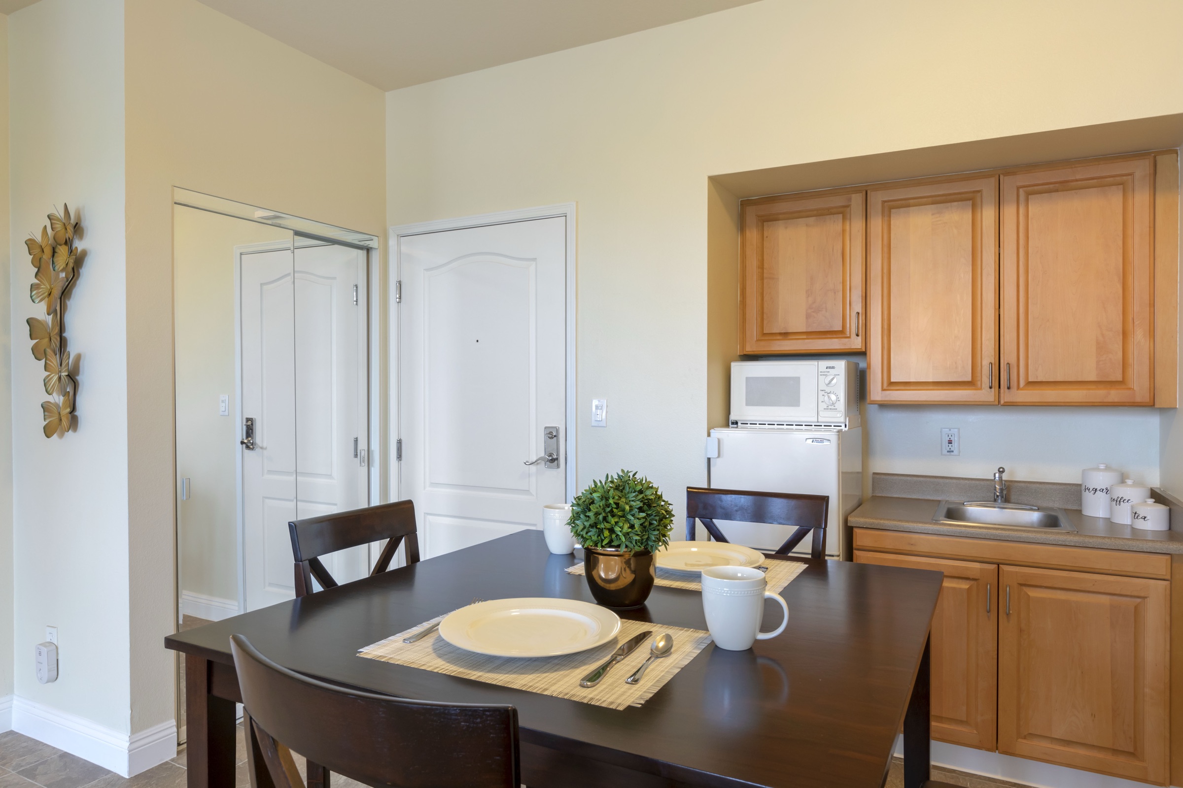 An apartment kitchenette with counter, cabinets and a sink