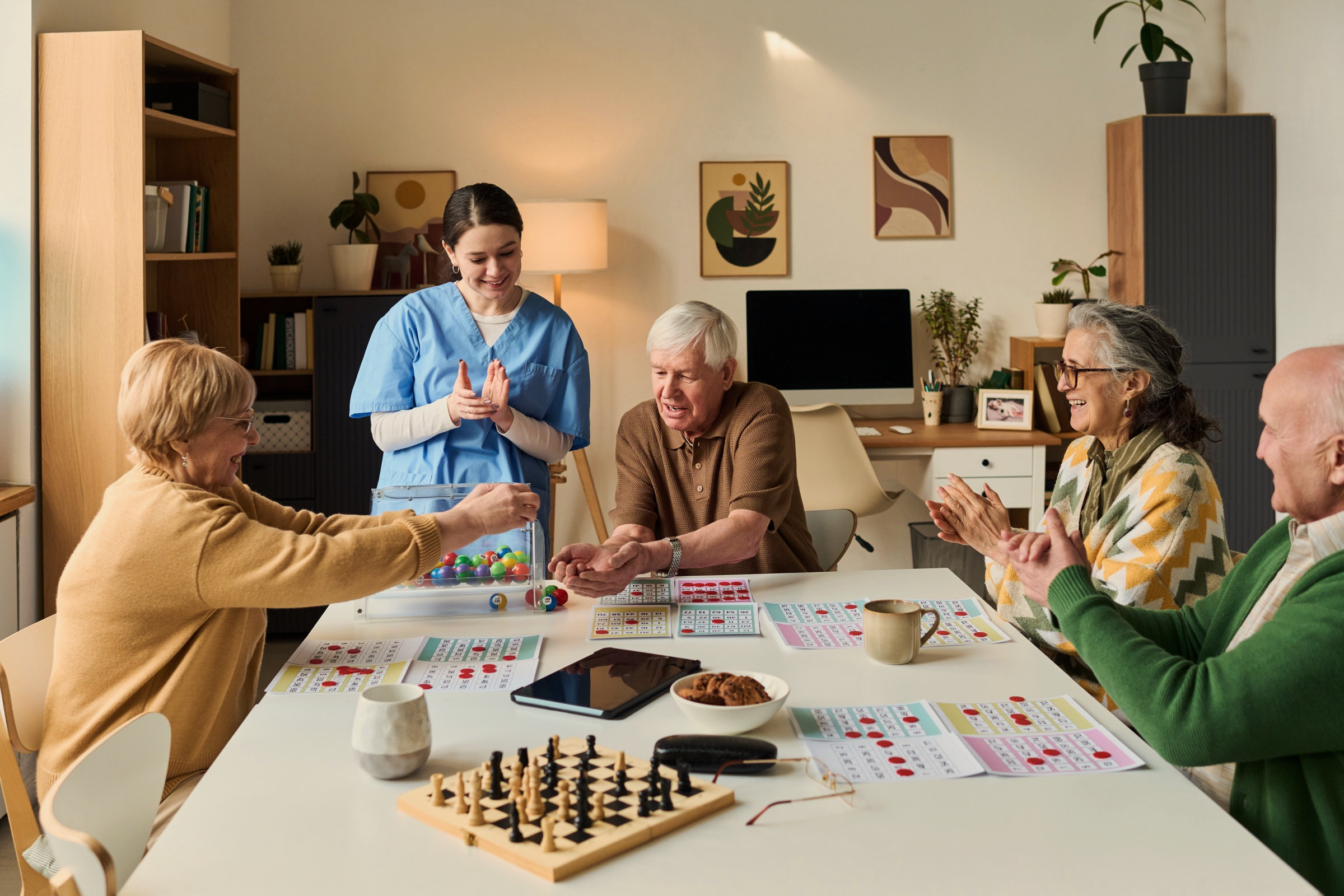 Residents around a low table over a game of cards